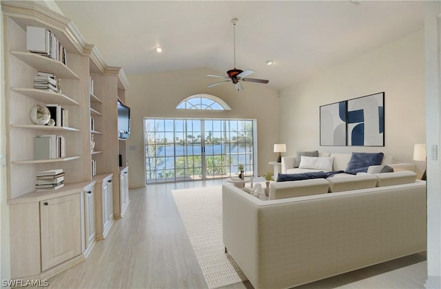 living room with light wood-type flooring, vaulted ceiling, and ceiling fan