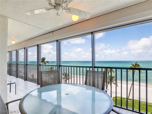 sunroom featuring a healthy amount of sunlight, a water view, and ceiling fan