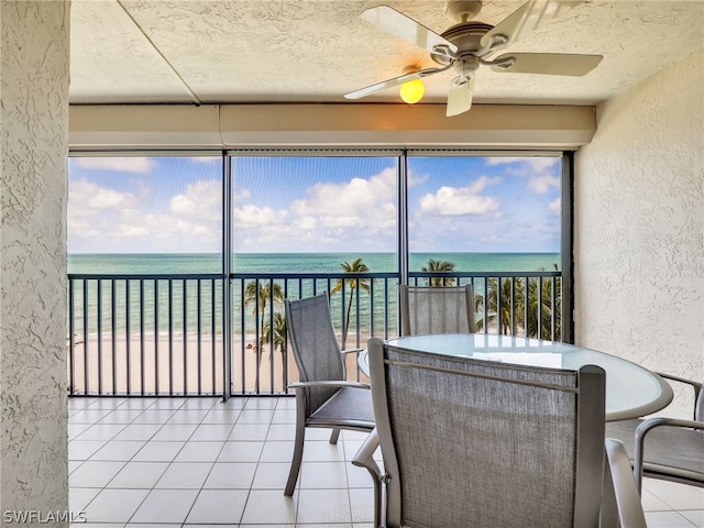 sunroom with a water view and ceiling fan