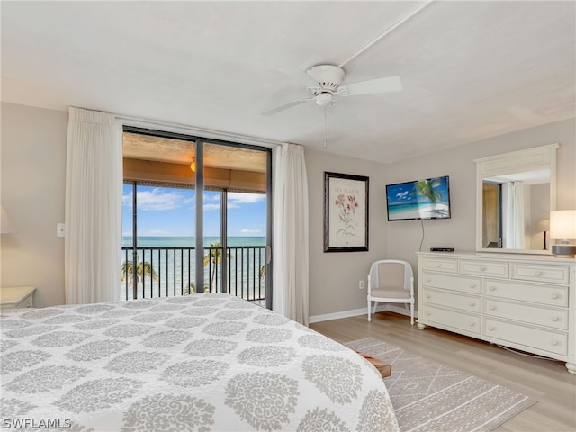 bedroom with a water view, ceiling fan, light hardwood / wood-style floors, and access to outside