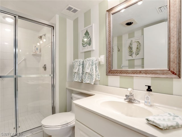 bathroom with a shower with door, vanity with extensive cabinet space, and toilet