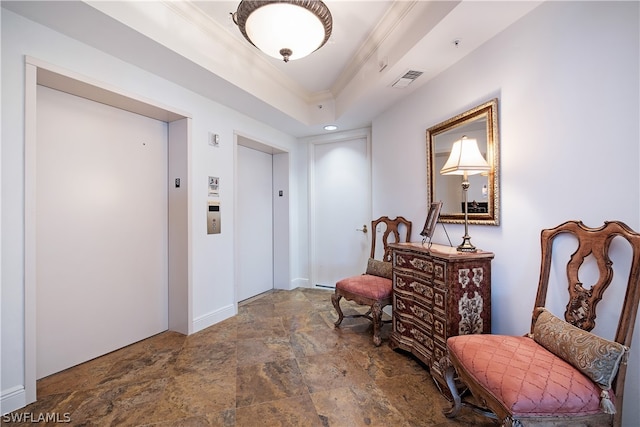 living area with elevator, a raised ceiling, and ornamental molding