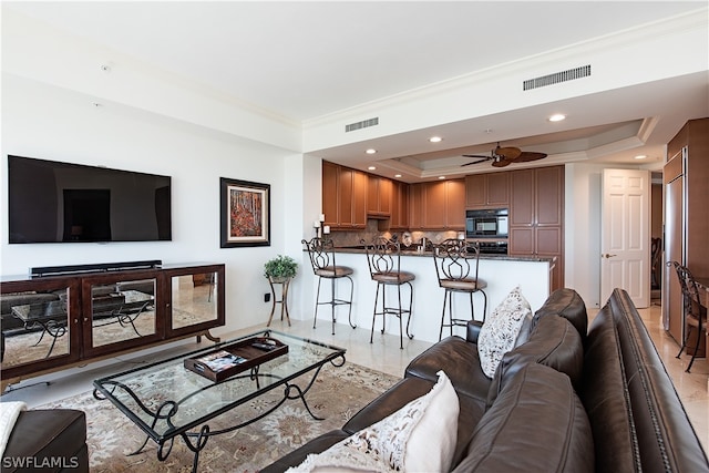 living room with ceiling fan, light tile patterned floors, crown molding, and a tray ceiling