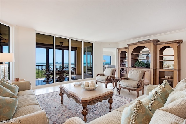 tiled living room featuring a water view, floor to ceiling windows, and crown molding