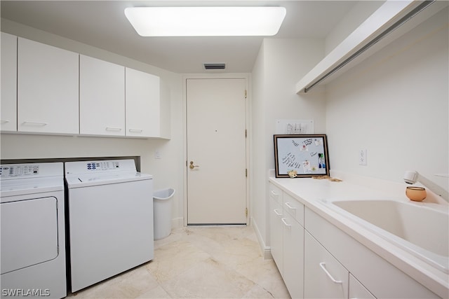 laundry area with washer and dryer, sink, and cabinets