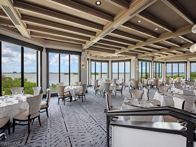 sunroom featuring beam ceiling, a water view, and coffered ceiling