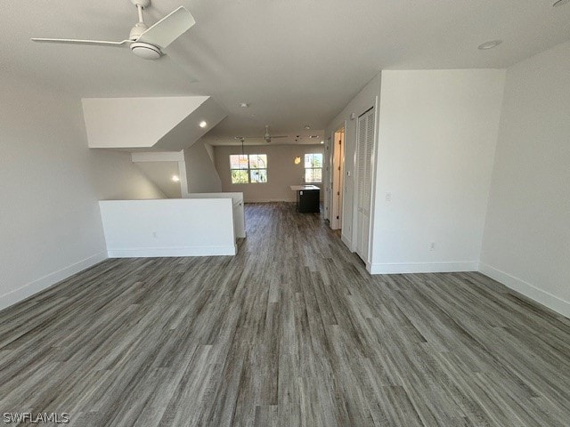 unfurnished room with vaulted ceiling, dark hardwood / wood-style flooring, and ceiling fan