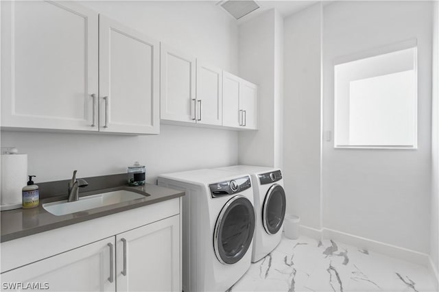 laundry area featuring cabinets, separate washer and dryer, and sink