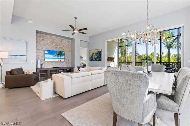 dining area featuring light wood-type flooring and ceiling fan with notable chandelier