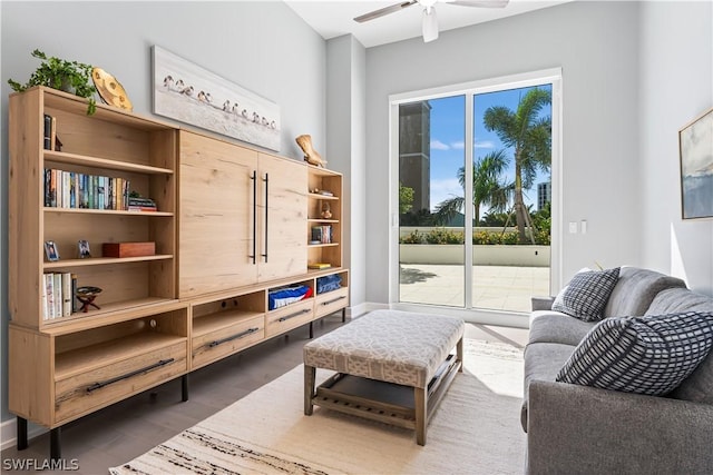 sitting room with ceiling fan and dark wood-type flooring