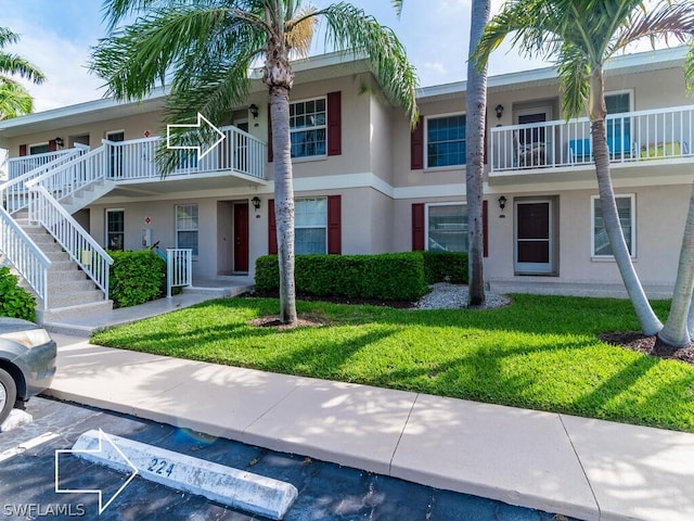 view of front of home with a front lawn and a balcony