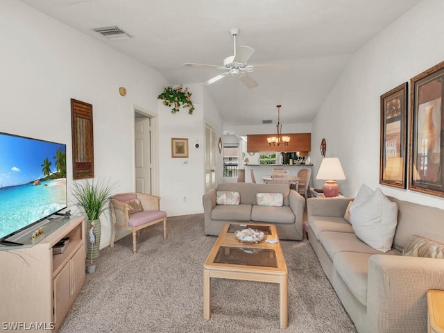 carpeted living room with vaulted ceiling and ceiling fan with notable chandelier