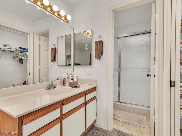 bathroom featuring tile floors, a shower with door, and large vanity