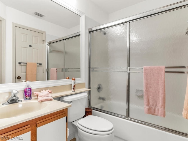 full bathroom featuring enclosed tub / shower combo, toilet, and vanity