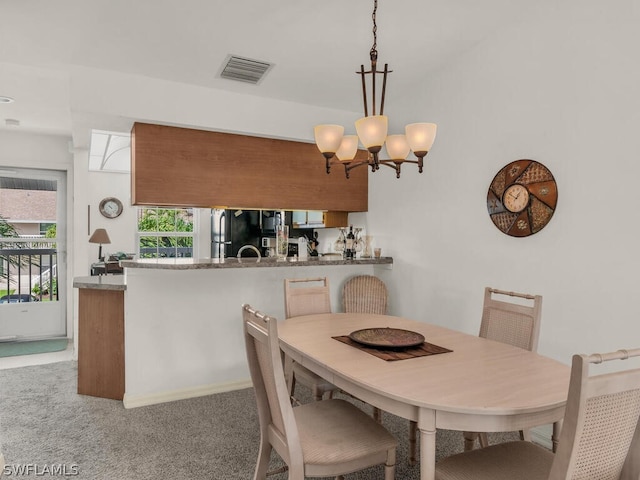 dining space featuring a chandelier and carpet flooring