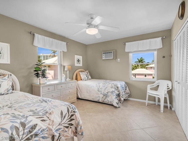 tiled bedroom featuring multiple windows, ceiling fan, a closet, and a wall mounted AC