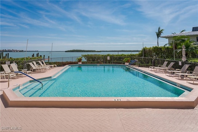 view of swimming pool with a patio and a water view