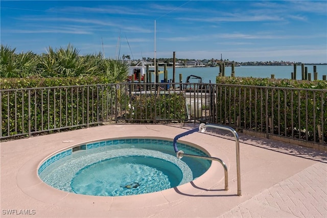 view of swimming pool with a water view and a hot tub