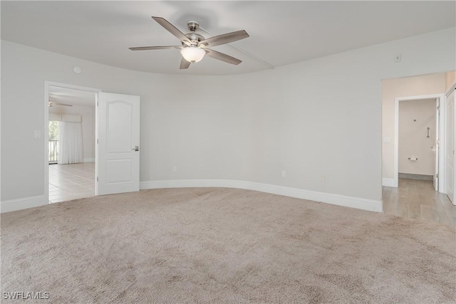 carpeted spare room featuring ceiling fan