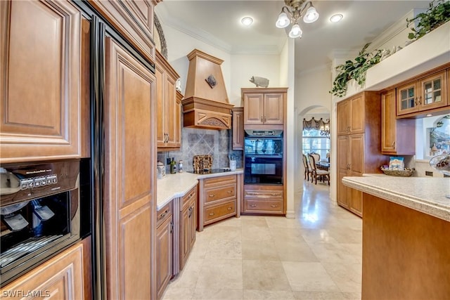 kitchen featuring arched walkways, crown molding, custom exhaust hood, light countertops, and black appliances