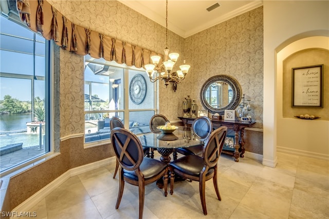 tiled dining space with a water view, a chandelier, and crown molding