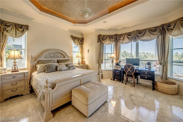 bedroom with marble finish floor, a tray ceiling, and crown molding