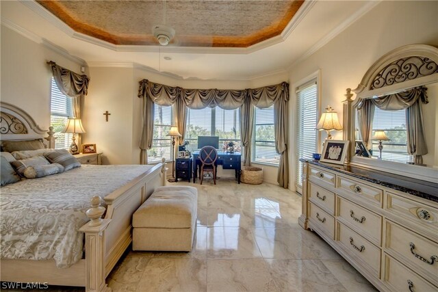 tiled bedroom with ceiling fan, a raised ceiling, and ornamental molding