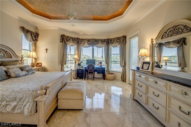 bedroom featuring ornamental molding, a tray ceiling, and multiple windows