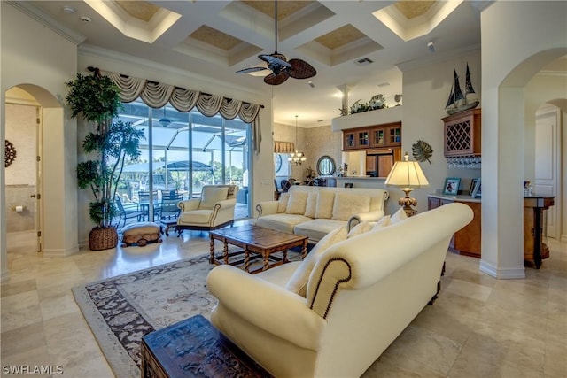 living room with coffered ceiling, crown molding, a high ceiling, and ceiling fan with notable chandelier