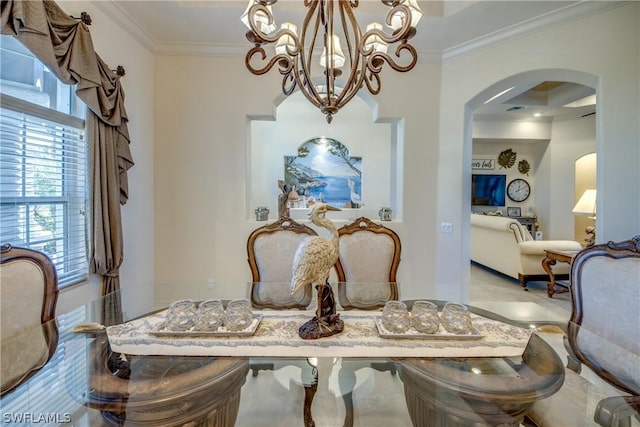 dining room featuring arched walkways, crown molding, and baseboards