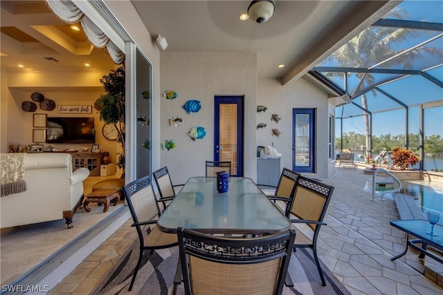 view of patio / terrace featuring outdoor dining space and a lanai