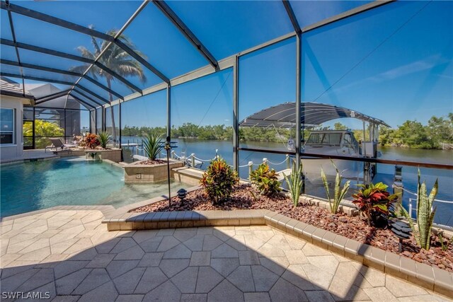 view of swimming pool with glass enclosure, pool water feature, a patio area, and a water view