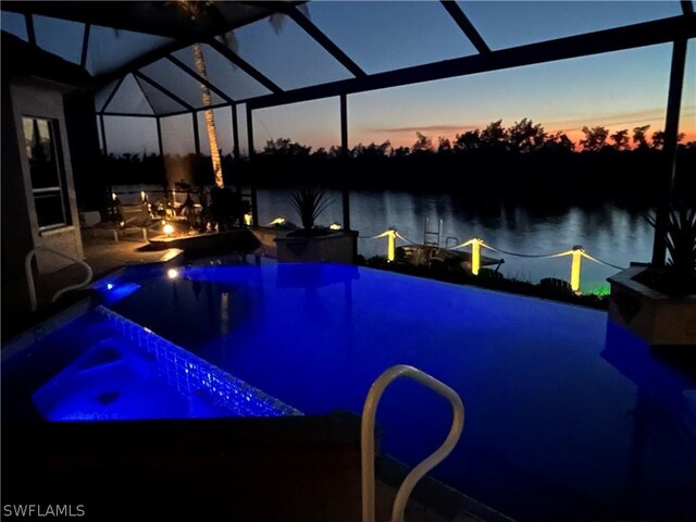 pool at dusk with glass enclosure and a water view