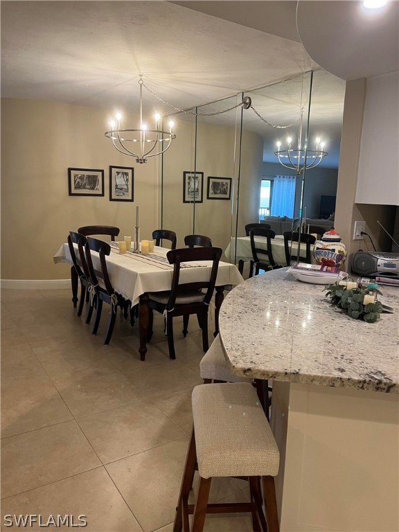 dining space featuring a notable chandelier and light tile floors