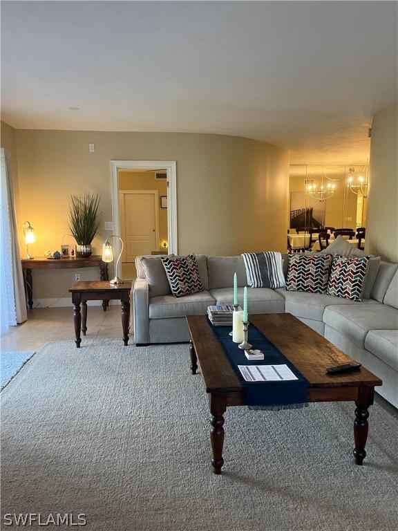 living room featuring a chandelier and carpet floors