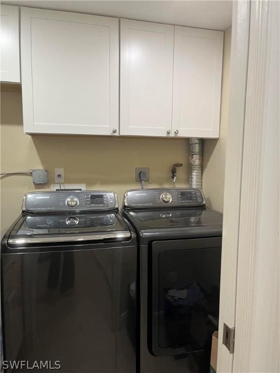 washroom with cabinet space and separate washer and dryer