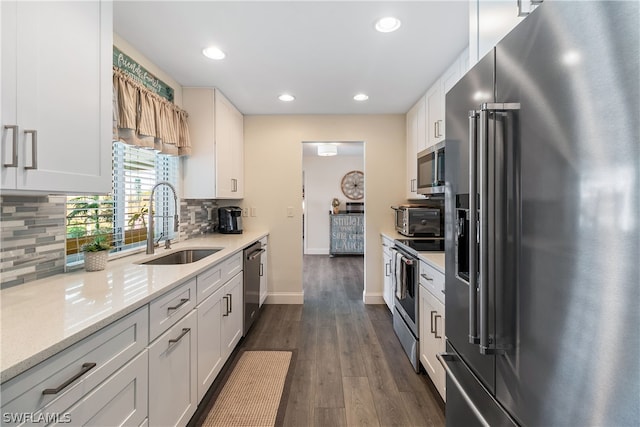 kitchen featuring tasteful backsplash, dark wood-type flooring, sink, white cabinetry, and stainless steel appliances