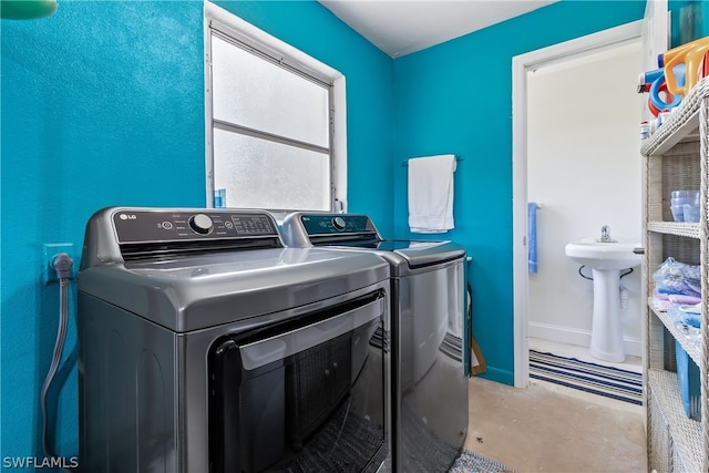 clothes washing area featuring sink and washing machine and dryer