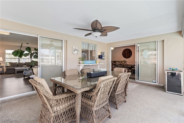 carpeted dining space featuring heating unit and ceiling fan