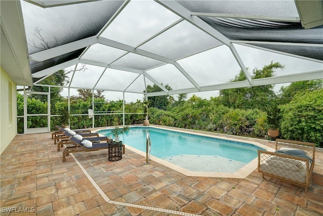 view of pool featuring glass enclosure and a patio