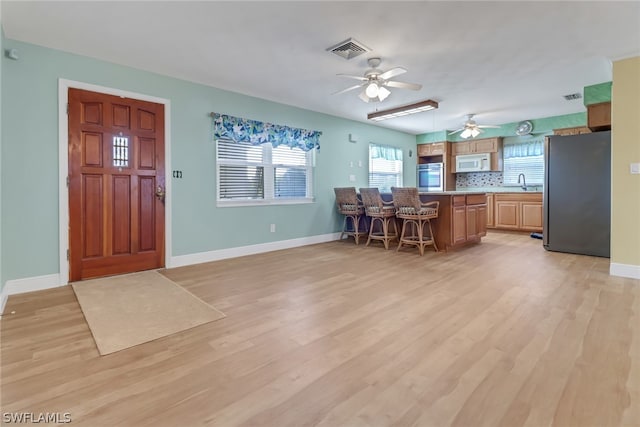 entryway with ceiling fan, light hardwood / wood-style flooring, and sink