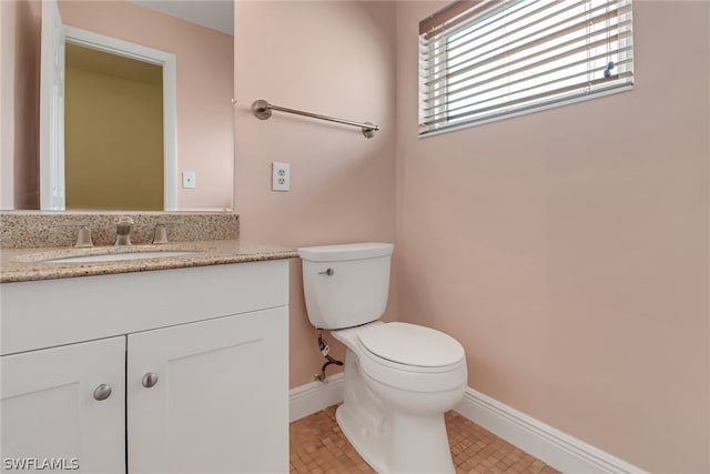 bathroom featuring vanity, toilet, and tile floors