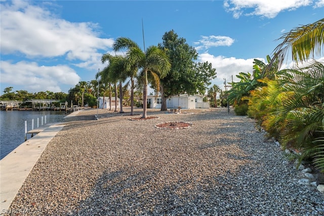 view of yard featuring a boat dock and a water view