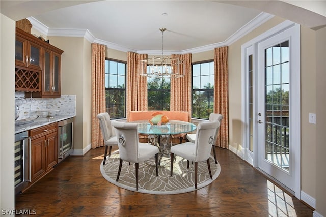 dining space featuring an inviting chandelier, beverage cooler, dark wood-type flooring, and plenty of natural light