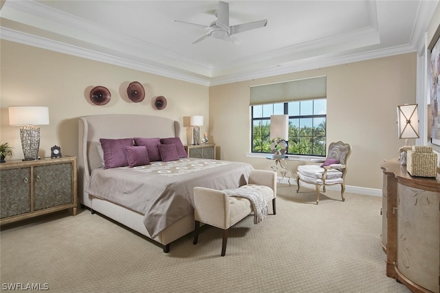 bedroom featuring ceiling fan, ornamental molding, light colored carpet, and a tray ceiling