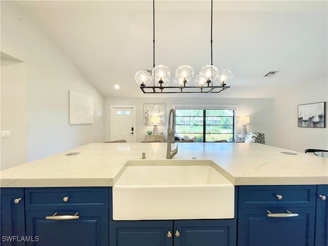 kitchen featuring blue cabinetry, sink, light stone counters, a notable chandelier, and lofted ceiling