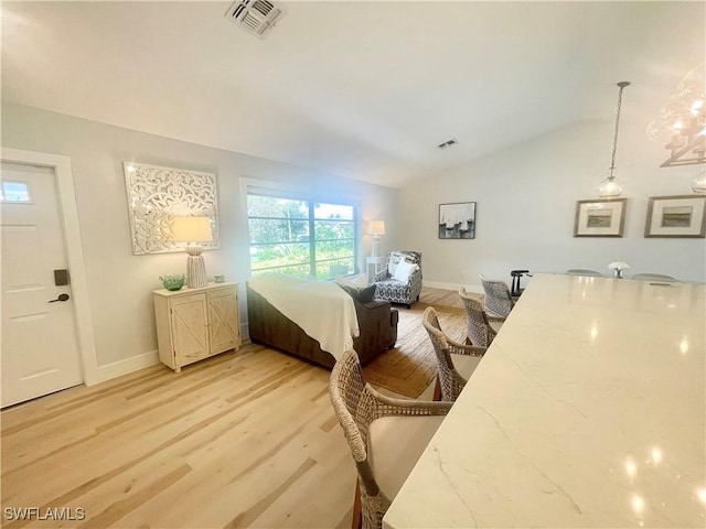 bedroom with light hardwood / wood-style floors and lofted ceiling