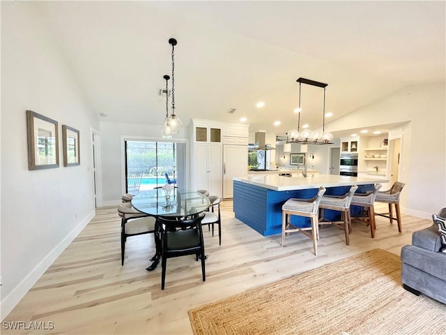 dining space with light hardwood / wood-style floors and lofted ceiling