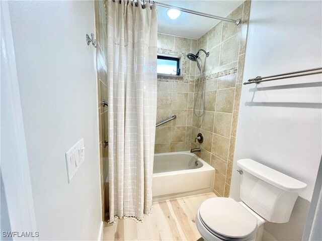 bathroom with hardwood / wood-style flooring, toilet, and shower / bathtub combination with curtain