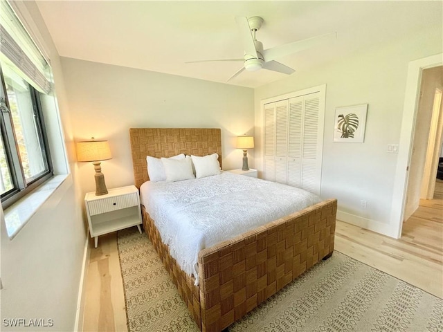 bedroom with ceiling fan, a closet, and light hardwood / wood-style floors